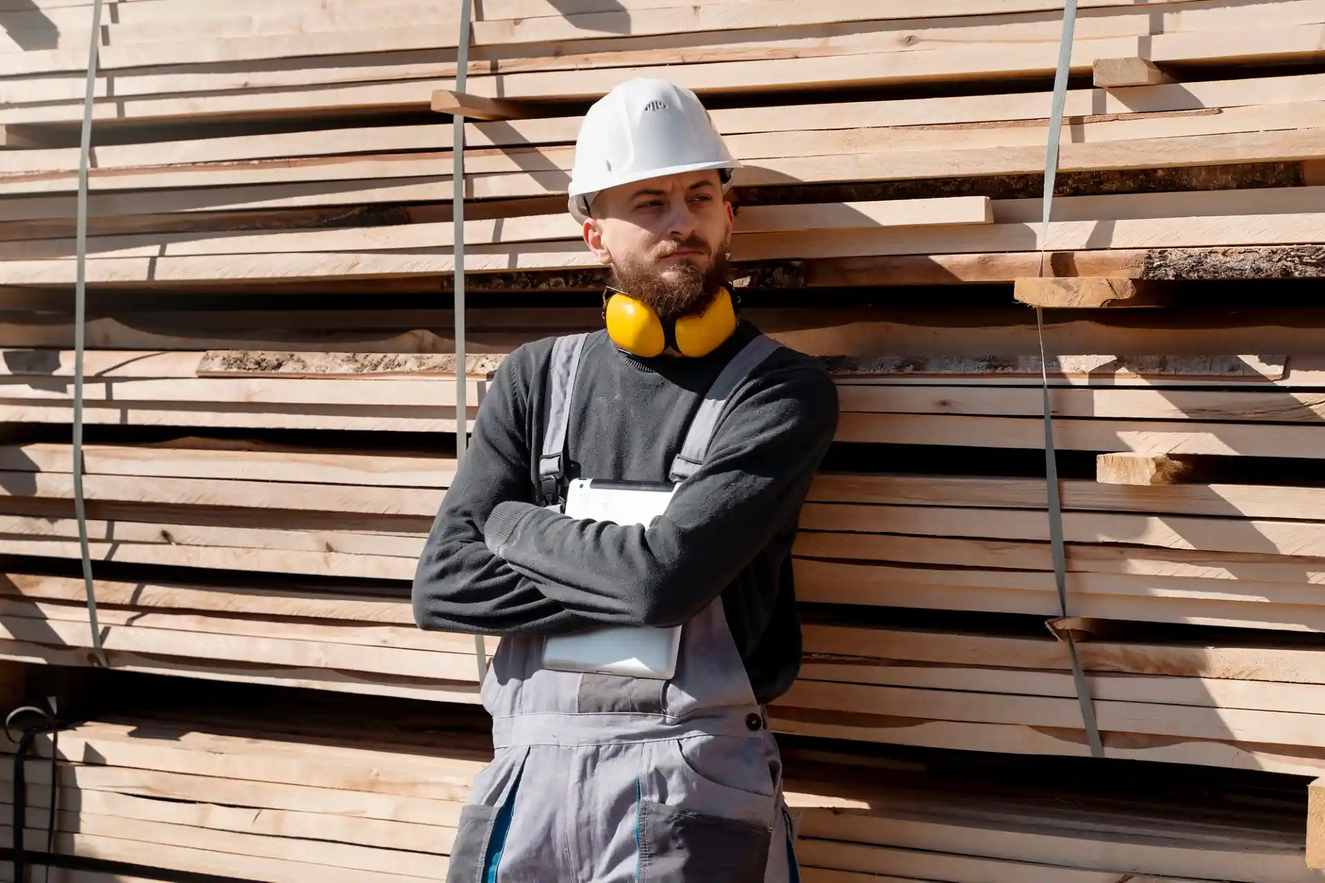 Handwerker vor Bauholz-Stapel – nachhaltige Ressource für Holz Investment und Zukunftsmärkte.